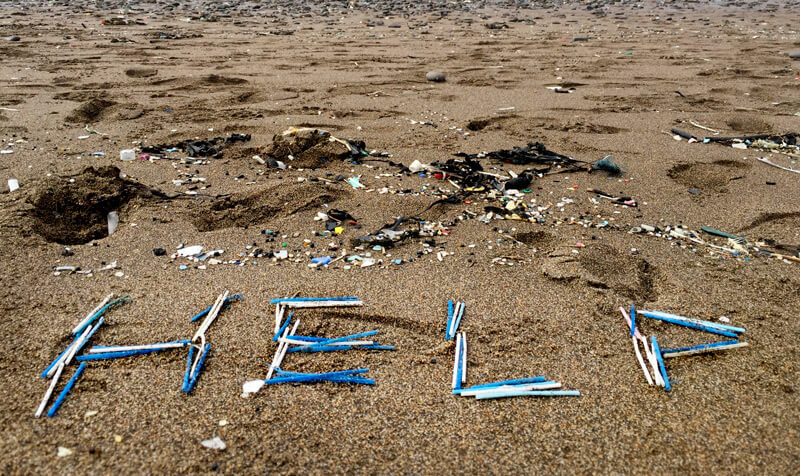 cotton buds on the beach spelling out help