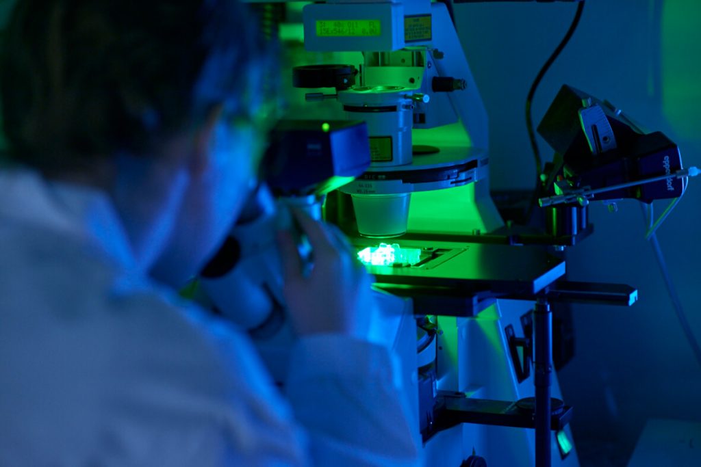 Scientist researching the breast cancer compound under a microscope