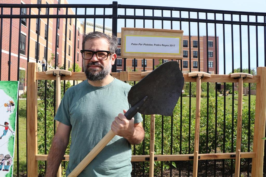 Pedro Reyes holds one of the shovels made from melted guns
