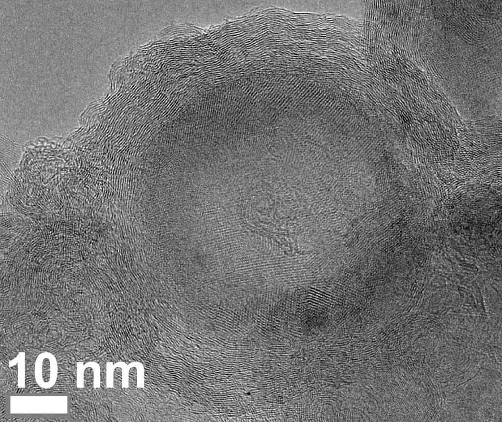 An electron microscope image shows the carbon and fluorine atoms' late evolutionary stage under flash Joule heating. The carbon atoms form concentric shells circling a nanodiamond core. The shell replaces the diamond phase as heating proceeds