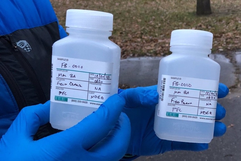 A scientist holds water samples for PFAS analysis