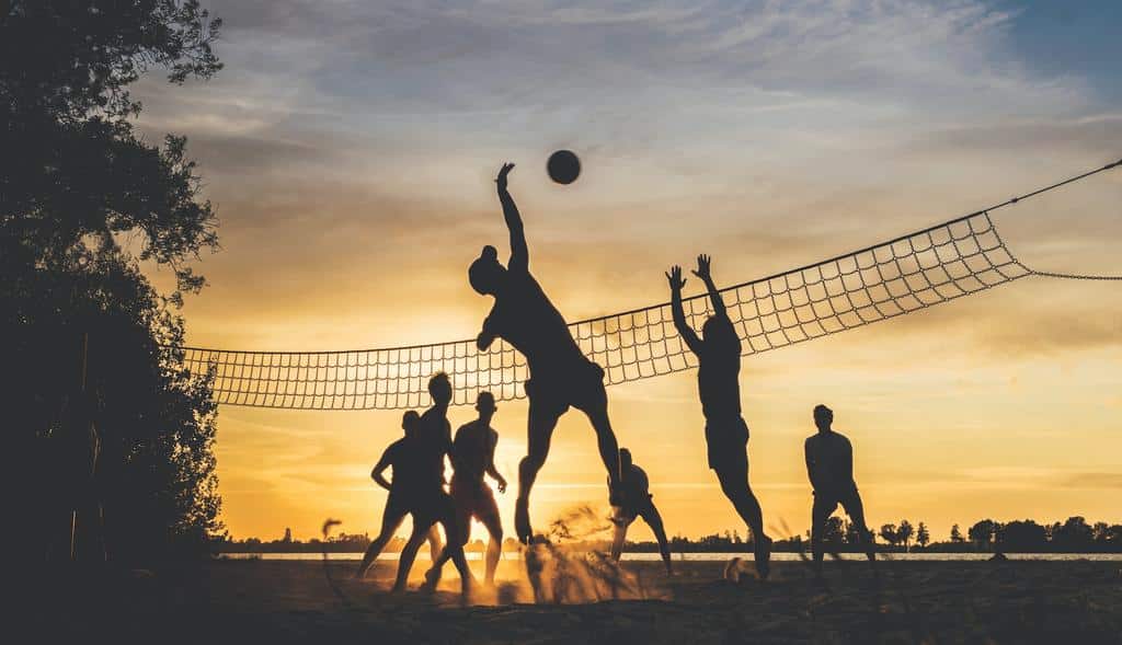 silhouettes of people playing volleyball