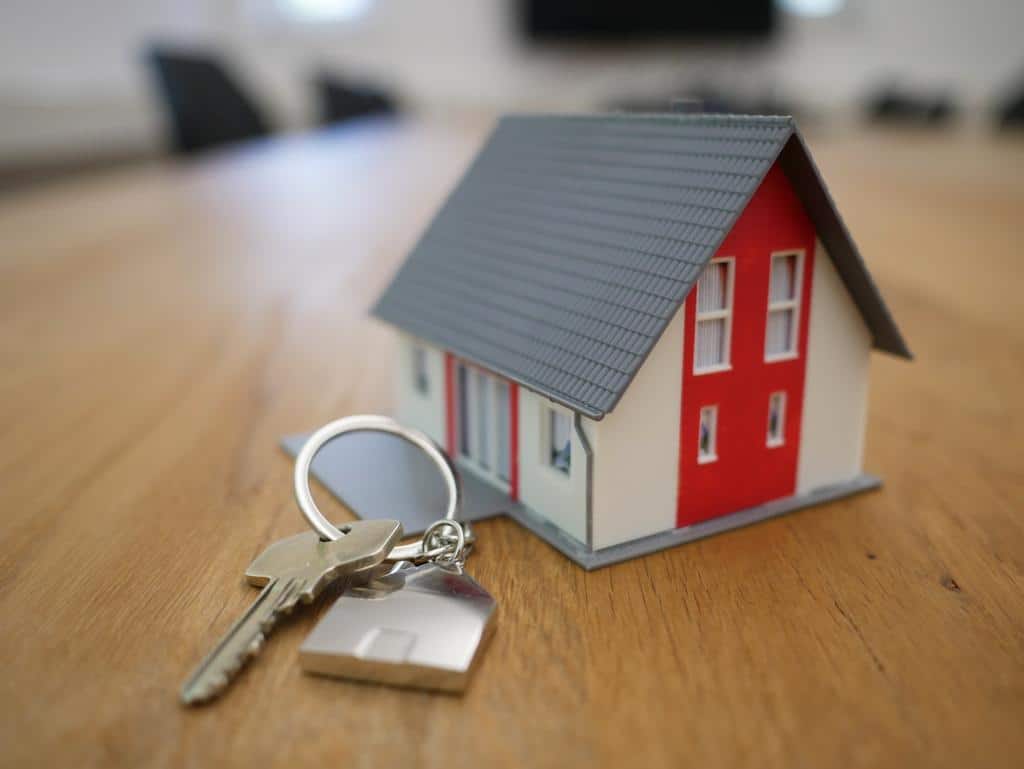 model of a house with a key next to it