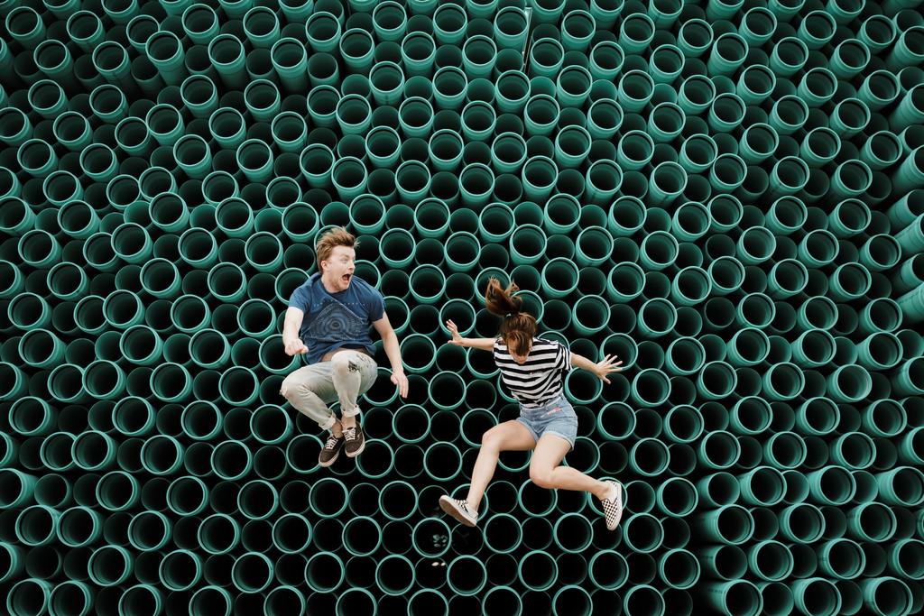 two people flying in the air from bouncing on a trampoline
