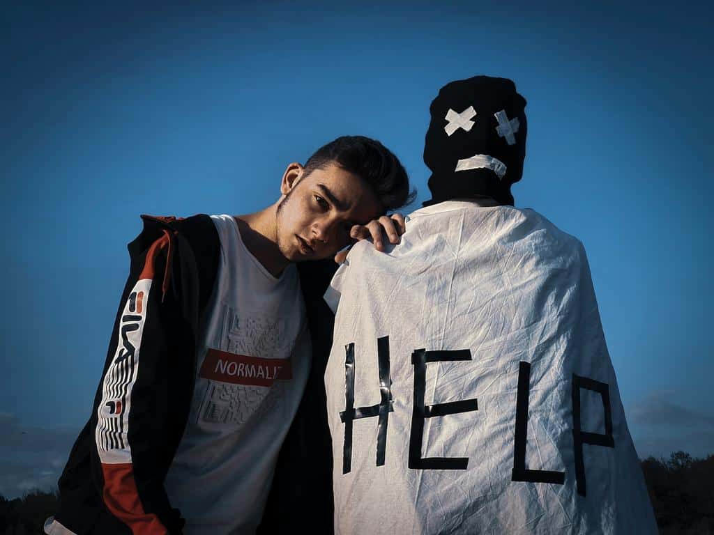 teen boy standing next to symbolism requesting help