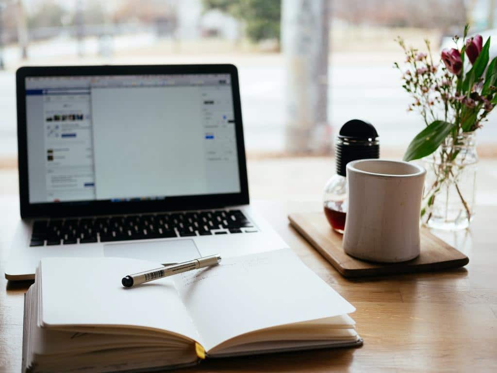 book in front of laptop for writing online content