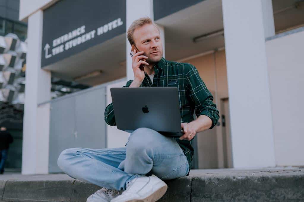person doing business on phone and laptop