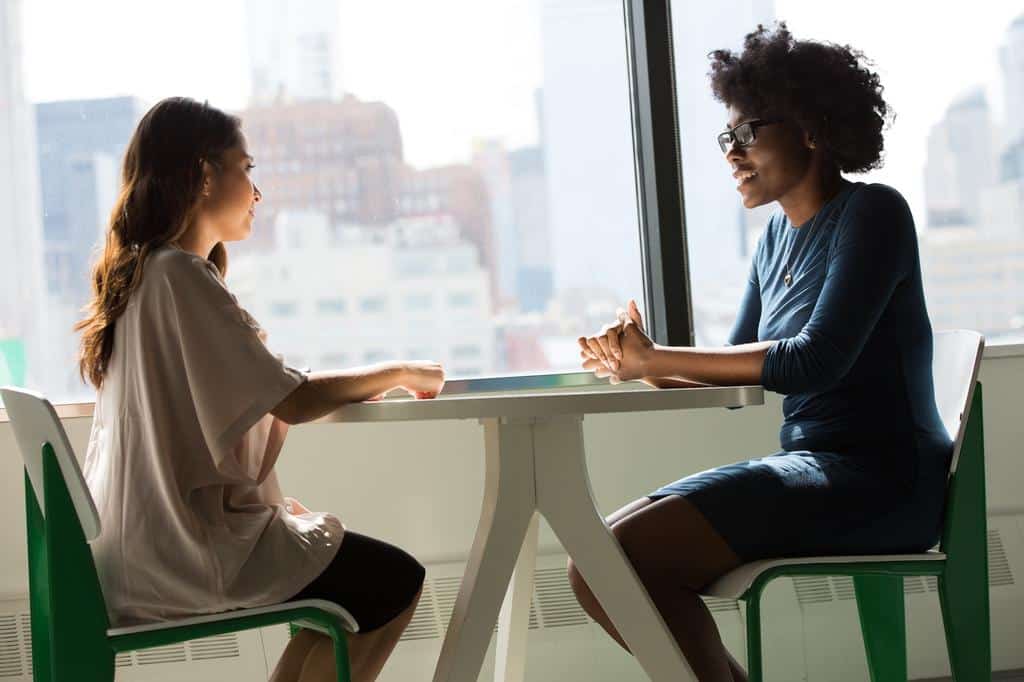 two women sitting at table