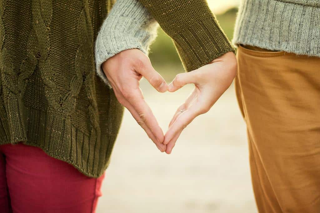 two people making heart shape with their hands