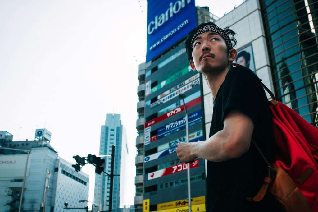 person standing in the city looking behind