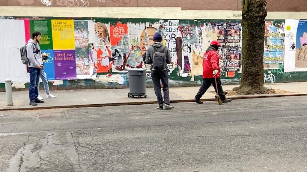 In the streets of Manhattan, a janitor is accompanied by a robotic trash barrel that can be controlled remotely