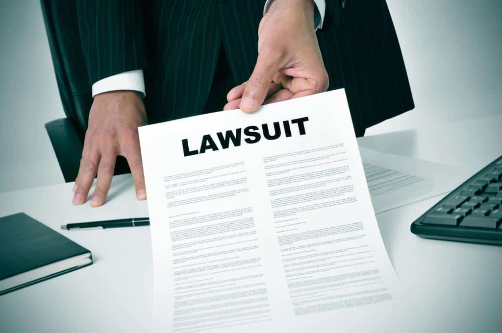 person holding paper with the word "Lawsuit"