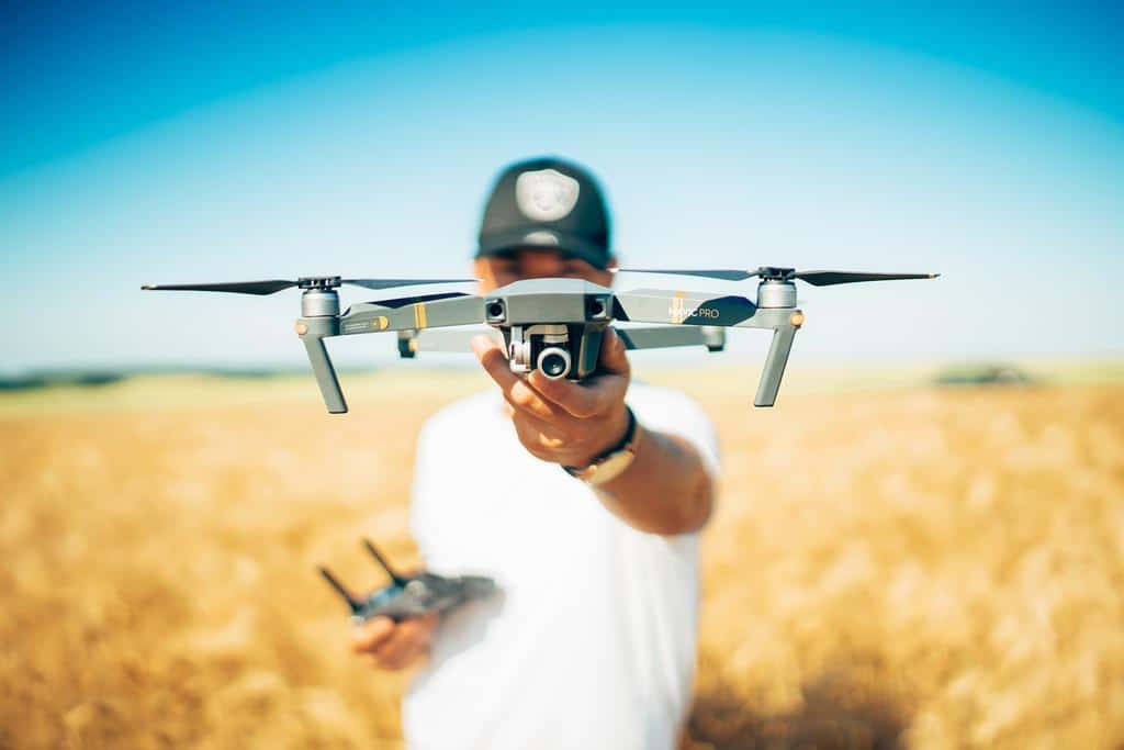 person holding a drone in an agriculture field