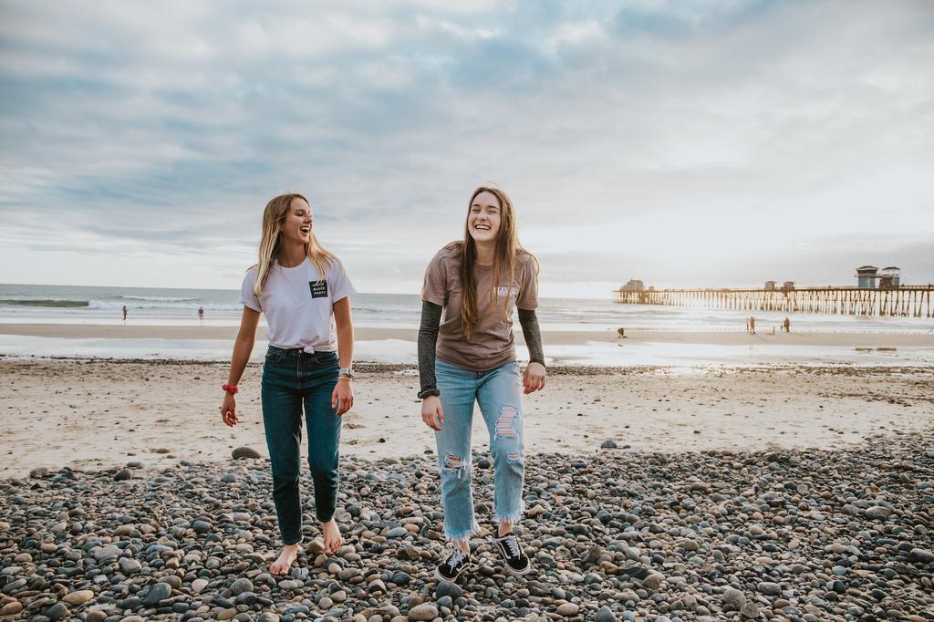 two girls walking along beach