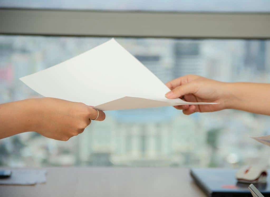 sheet of paper passed between two people