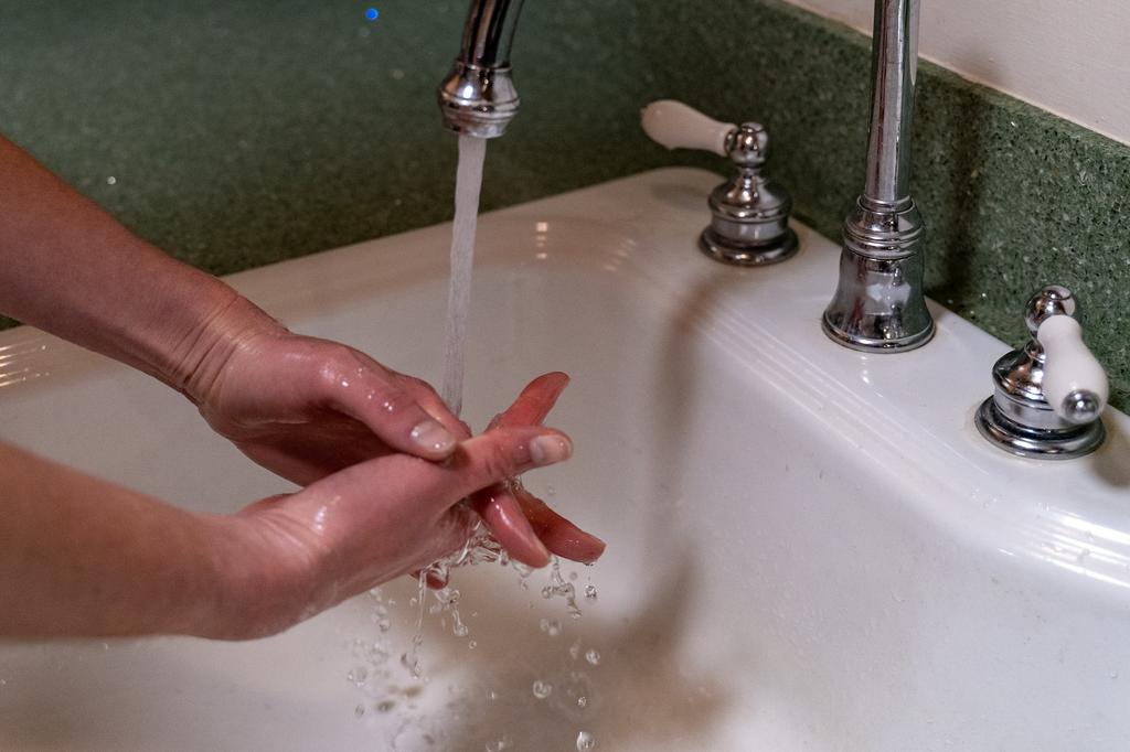 person washing hands at sink