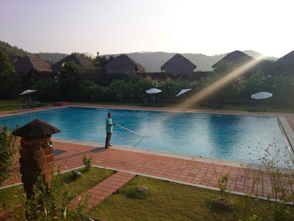person cleaning large outdoor pool