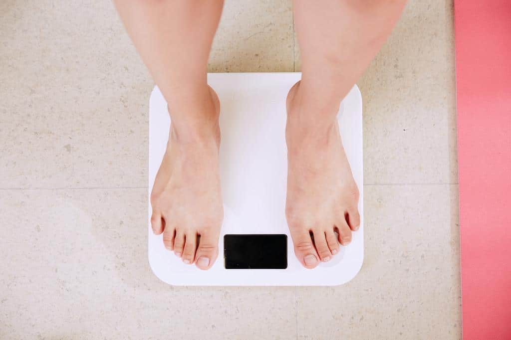 person standing on scale measuring weight