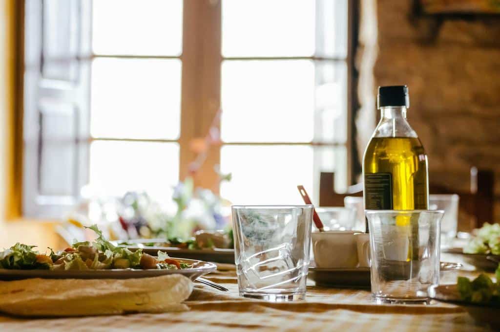 olive oil, drink glasses, and meals atop table