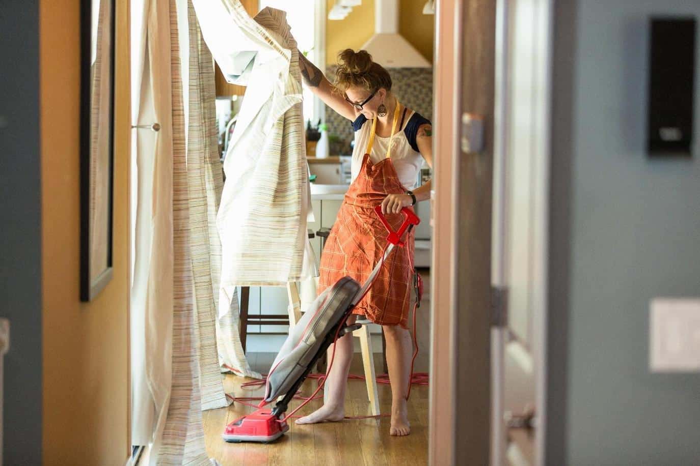woman vacuuming with green cleaning products