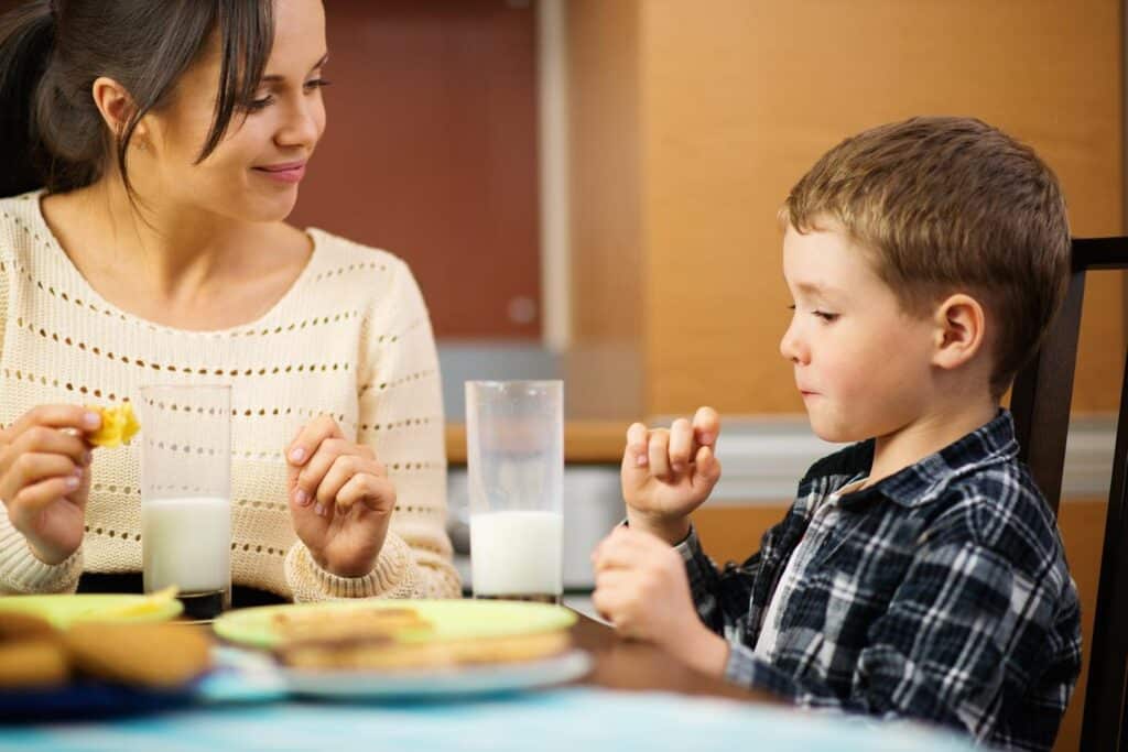Child eating a meal with his mother
