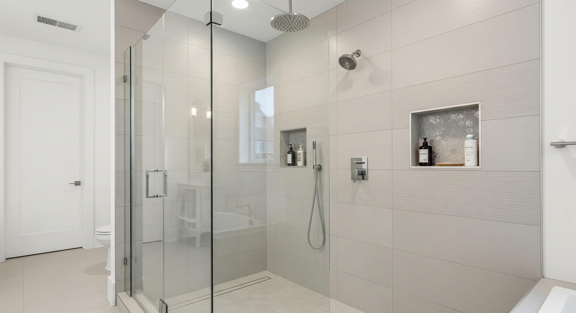 Modern walk-in shower with frameless glass enclosure and rainfall showerhead