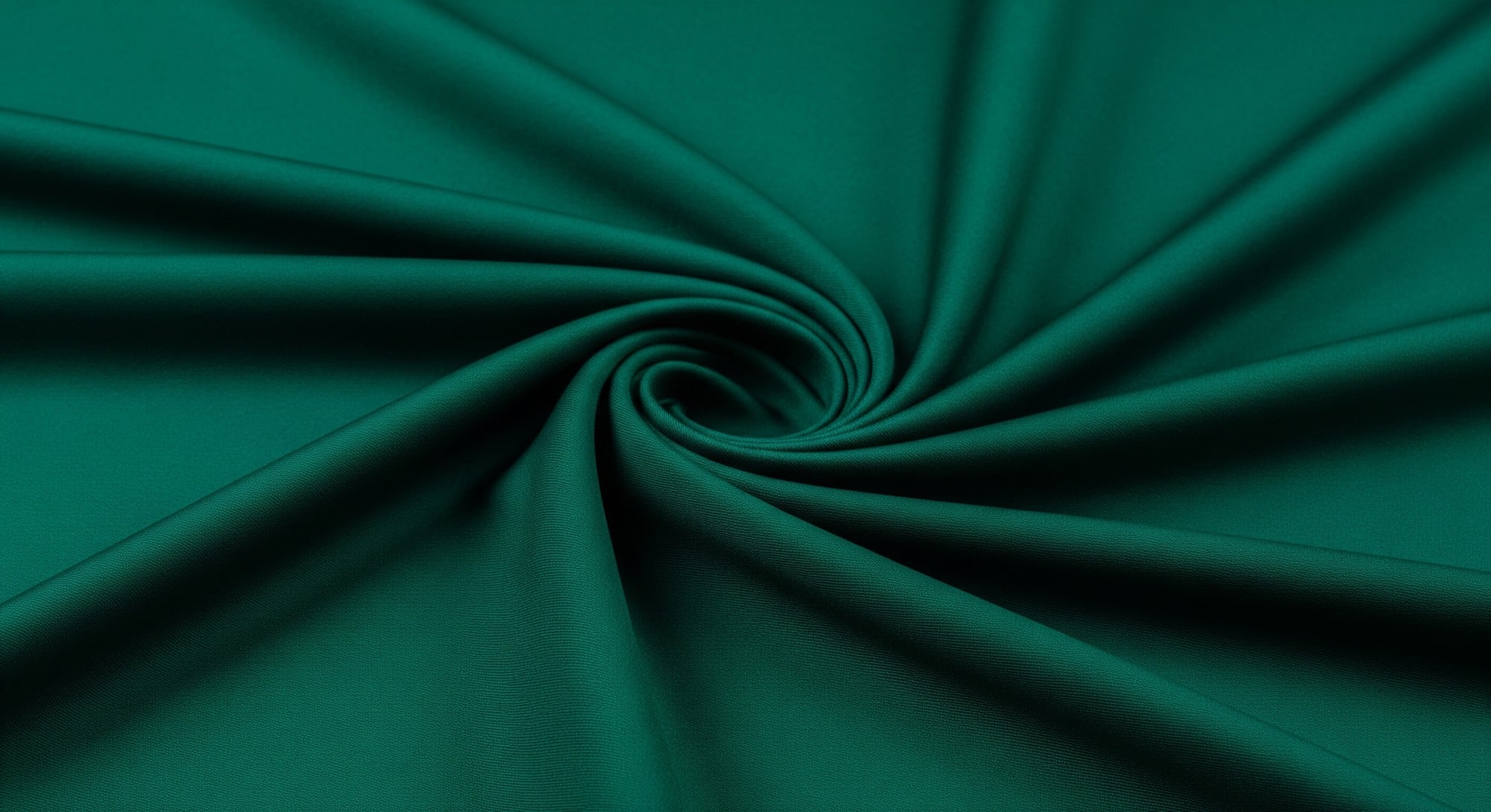A high-detail close-up of luxurious deep emerald silk fabric with soft, elegant folds.