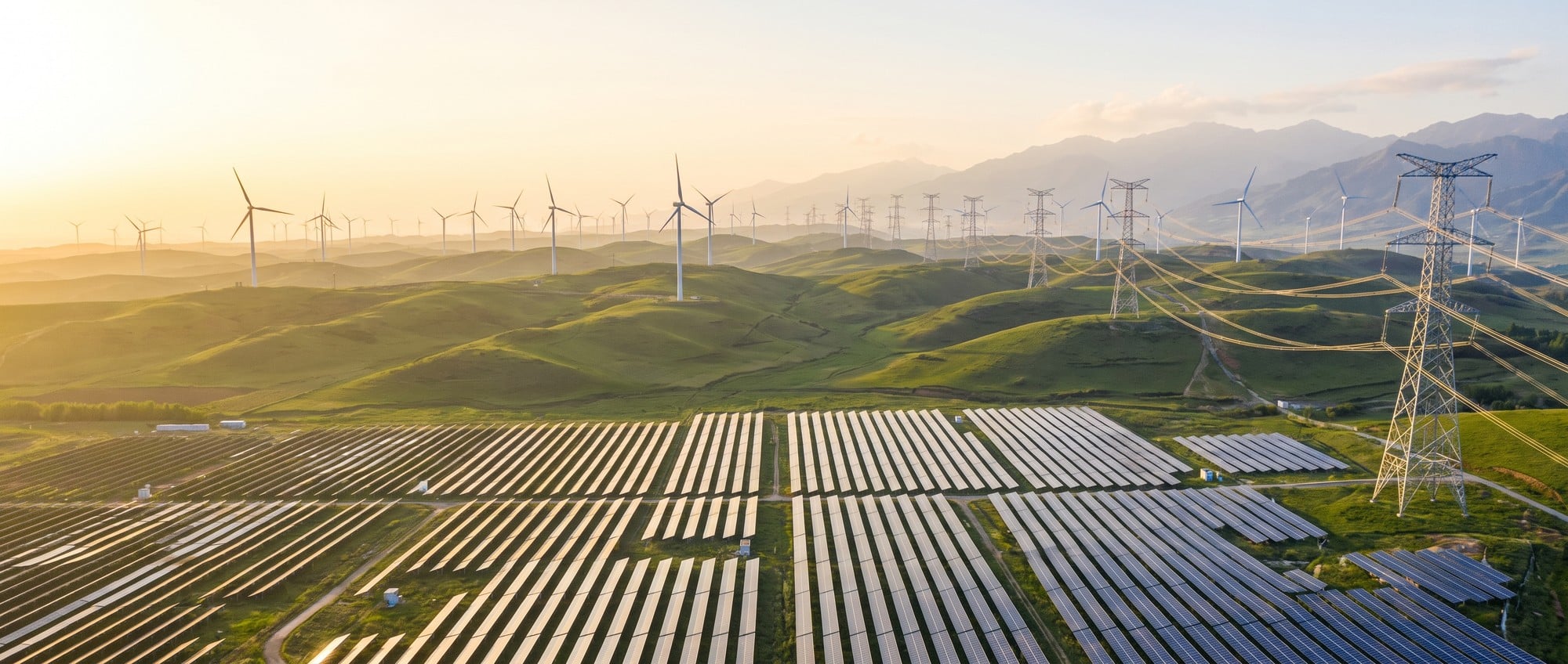 China Renewable Energy Growth Hits Record but Grid Lags Behind Aerial view of a renewable energy complex in China with solar panels, wind turbines, and transmission towers