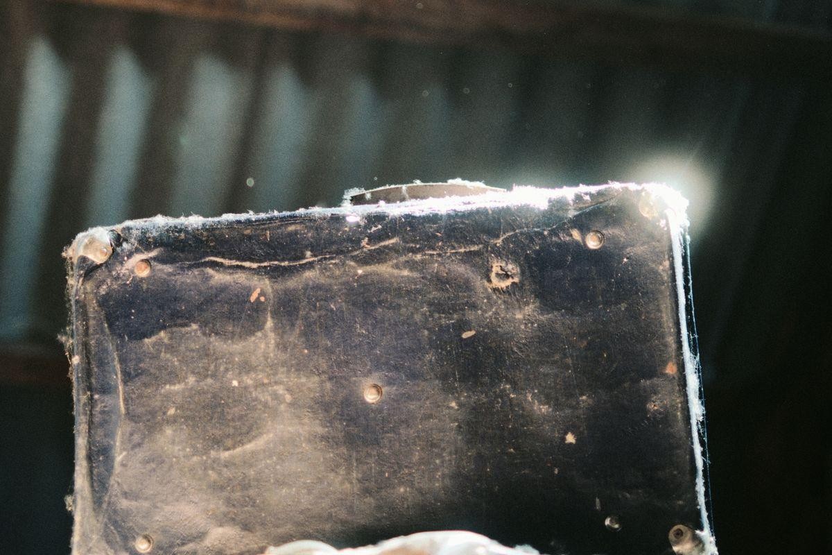 Minnesota Mesothelioma Lawyers: What to Expect During the Claims Process Close-up shot of a dusty, dark blue, old-fashioned suitcase or briefcase, with light glinting off its worn surface.