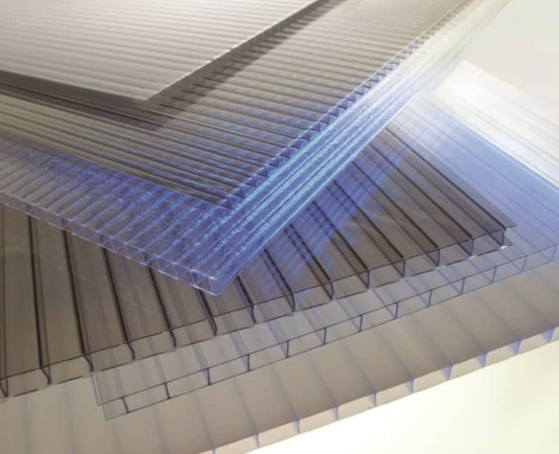 A stack of clear, corrugated plastic sheets with a bluish tint.