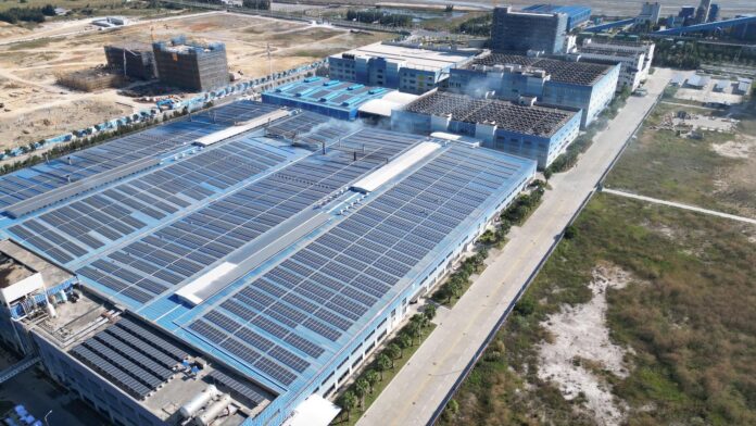 solar-panels-industrial-roof Aerial view of a large industrial warehouse roof covered with solar panels.