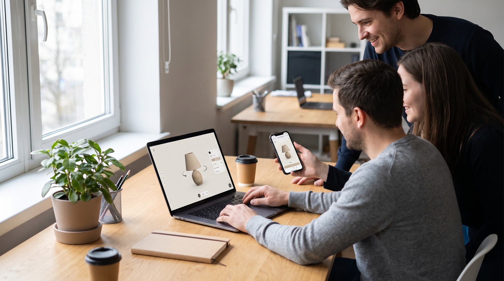 A small team reviewing an interactive 3D product preview on a laptop and a smartphone
